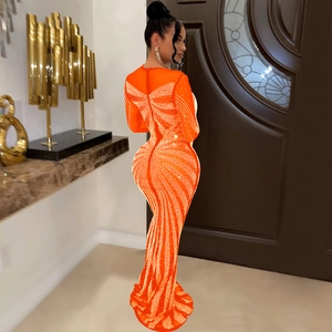 Close-up of sparkling silver rhinestones forming a large bow pattern on orange mesh dress