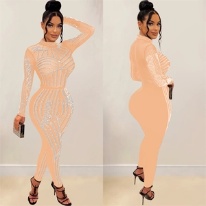 Detail of sheer mesh jumpsuit featuring hot-fix rhinestones and slim fit long sleeves
