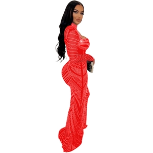 Détail d'une robe de soirée rouge en mesh avec strass et manches longues voilées