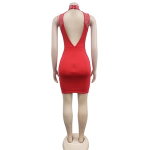 Détail d'une robe moulante rouge dos nu avec des ornements en strass sur le col licou
