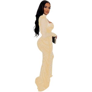 Détail de la robe en mesh champagne avec des motifs en strass et des manches longues