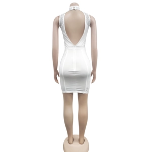 Détail de la robe blanche dos nu avec décolleté en V profond et bordure en strass