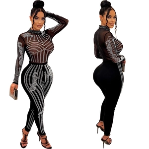 Close-up of sparkling rhinestones and mesh texture on a black long-sleeve jumpsuit