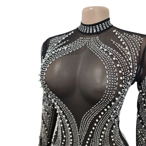 Détail de robe en tulle transparent avec strass, perles et plumes aux manches