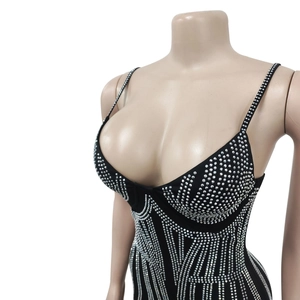 Détails d'une robe noire ornée de motifs géométriques en strass argentés et col en V profond