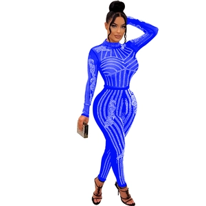 Detailed close-up of bright blue sheer mesh jumpsuit with sparkling rhinestone pattern