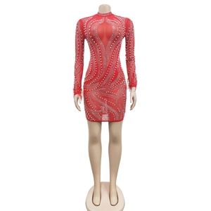 Détail de robe rouge en résille avec perles, strass et poignets en plumes de luxe
