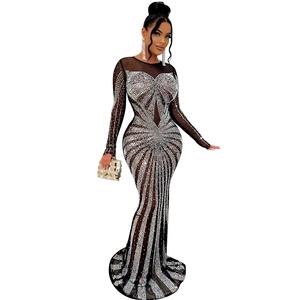 Detail of sheer mesh dress featuring intricate silver rhinestones and floor-length fishtail hem