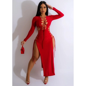 Détail d'une robe rouge à manches longues avec laçage évidé et doubles fentes latérales