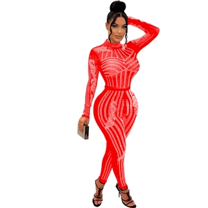 Detail of red mesh jumpsuit with long sleeves featuring intricate sparkling rhinestone patterns