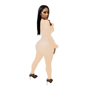 Close-up of beige mesh jumpsuit featuring sparkling white rhinestones and slim-fit texture