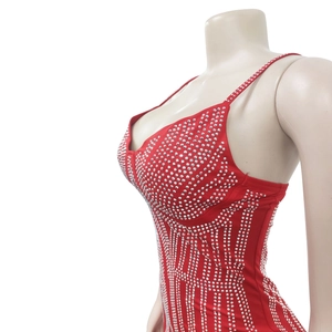 Détail d'une robe moulante rouge avec strass argentés brillants et fines bretelles