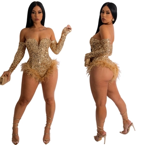 Detail of gold sequins and plush feather trim on the waist and hem of a party romper