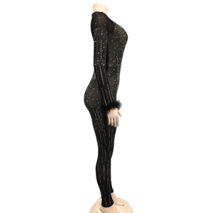 Detail view of black rhinestone jumpsuit with long sleeves and feather cuffs on the sleeve