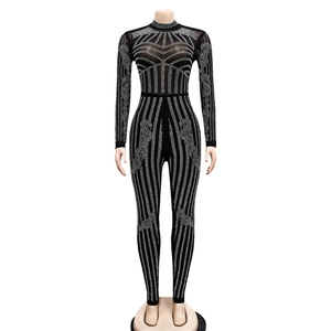 Detail of black mesh jumpsuit with high collar and geometric silver rhinestone patterns