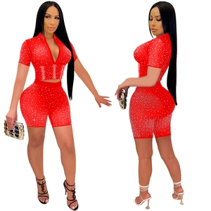 Detail of red mesh two-piece set with shiny rhinestones, short sleeve top and shorts