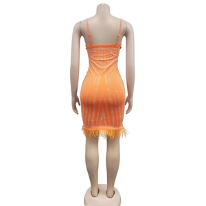 Vue détaillée du dos de la robe orange moulante avec strass et bordure en plumes
