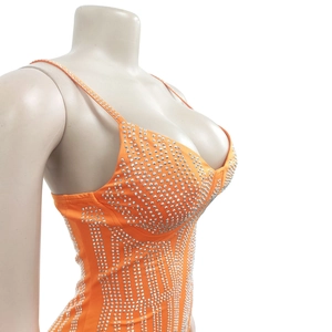 Détail de la robe orange montrant les motifs de strass argentés et les fines bretelles