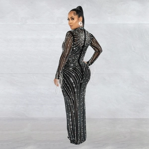 Detailed view of silver rhinestones and long fringe tassels on a black mesh party dress