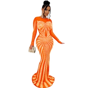 Detail of orange mesh evening gown with shimmering rhinestones and sheer sleeve panels