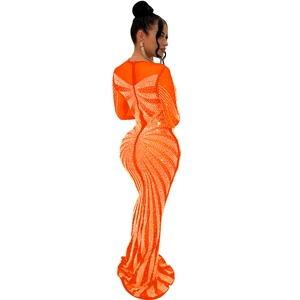 Close-up of sparkling rhinestones and radial pattern on an orange mesh maxi dress