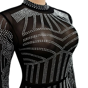 Close-up of black mesh jumpsuit featuring intricate silver rhinestone patterns and textures