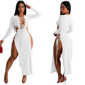 Détail de la robe blanche à manches longues avec lacets ajourés et fente haute