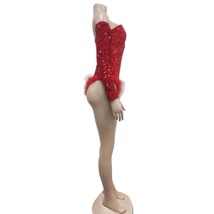 Side view of red sequin bodysuit featuring long sleeves and festive red feather trim