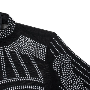 Detail of sheer black mesh top featuring sparkling silver rhinestones in a letter pattern