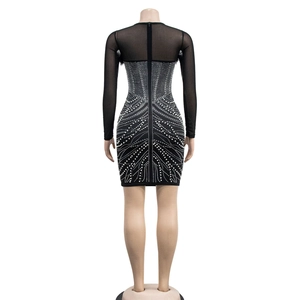 Detail of black rhinestone bodycon dress featuring sheer mesh sleeves and back zipper