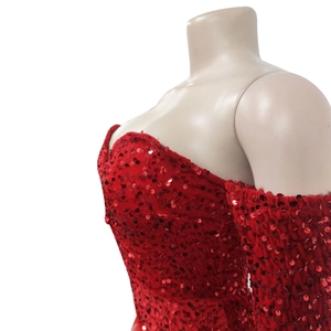 Detail shot of shimmering red sequins on a formal dress with elegant off-shoulder sleeves