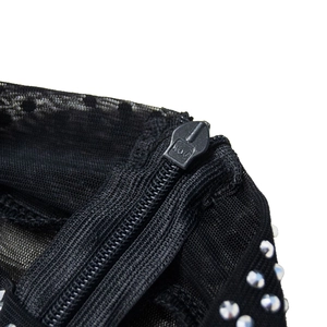 Detail of invisible back zipper and silver rhinestones on sheer black mesh fabric