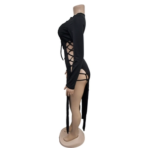 Détail de la découpe latérale à lacets et de la fente sur une robe noire à manches longues