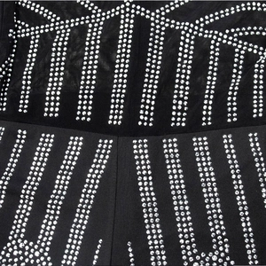 Detailed macro view of black mesh fabric with silver rhinestone geometric patterns