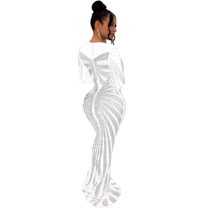 Close-up of white mermaid evening dress with intricate wave pattern rhinestones and long sleeves