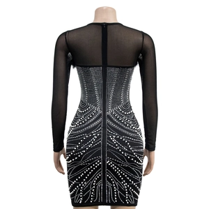 Macro detail of sheer mesh back and intricate rhinestone wave patterns on black mini dress