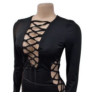 Détail d'une robe noire à manches longues avec laçage croisé et découpes audacieuses