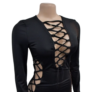 Détail de la robe noire à manches longues montrant le design de découpe à lacets