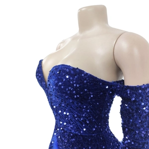 Detail of dark blue sequined off-shoulder jumpsuit with velvet fabric and long sleeves