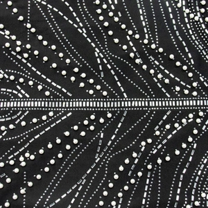Macro shot of exquisite pearl embroidery and sparkling rhinestone details on black mesh dress