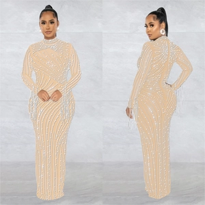 Detail of nude mesh maxi dress featuring white beadwork, sequins and fringed cuffs