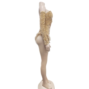 Detail of gold sequin long sleeve romper with faux fur trim for festive stage wear