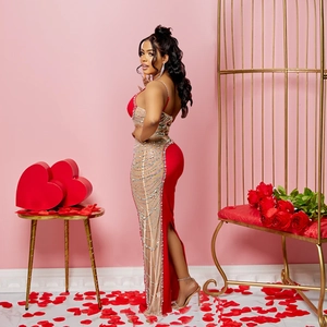 Détail d'une robe de soirée rouge avec tulle transparent, strass et fente latérale haute