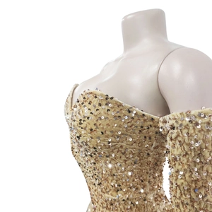 Detail of shimmering gold sequins on a strapless slim-fit jumpsuit for party wear