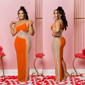 Détail de robe de soirée orange avec paillettes argentées et coupe asymétrique épaule