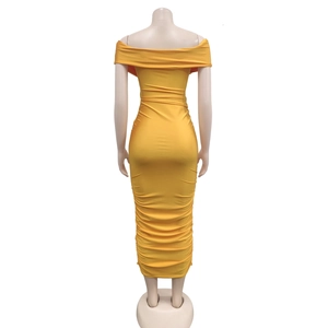Detail view of the shirred pleats and slim fit tailoring on a ginger off-shoulder dress
