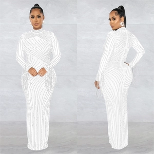 Detail of white mesh dress featuring sparkly rhinestones and elegant fringe on sleeves