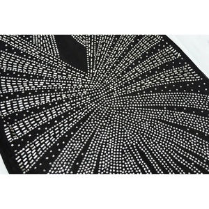 Detailed close-up of sparkling silver rhinestones on black mesh fabric long sleeve dress