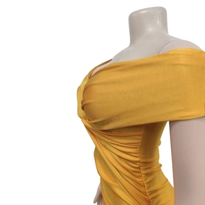 Detail of side ruching and glossy elastic fabric on a yellow off-shoulder dress