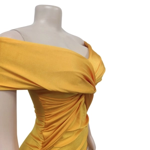 Detail of ruched yellow strapless maxi dress with criss-cross neckline and sleek fabric